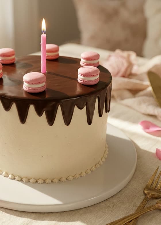 Detail of the same photographed cake — macarons and candle